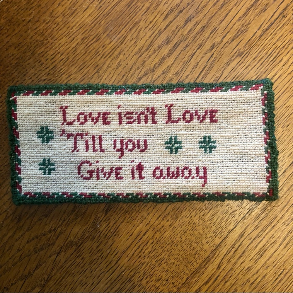 Needlepoint with phrase “Love isn’t Love Till you Give it away”